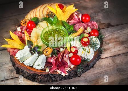 Carte alimentaire antipasti avec différents types de fromage, viandes à base de curis, herbes et fleurs comestibles Banque D'Images