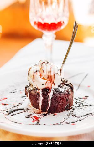 Gâteau au caramel au chocolat avec crème glacée et cocktail, concentration sélective Banque D'Images