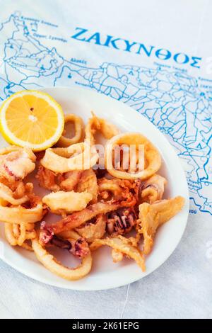 En-cas grec typique - calamars frits servis sur une carte de l'île de Zakynthos Banque D'Images
