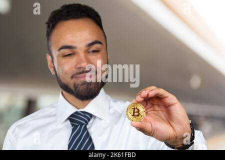 Jeune afro-américain avec bitcoin en main Banque D'Images