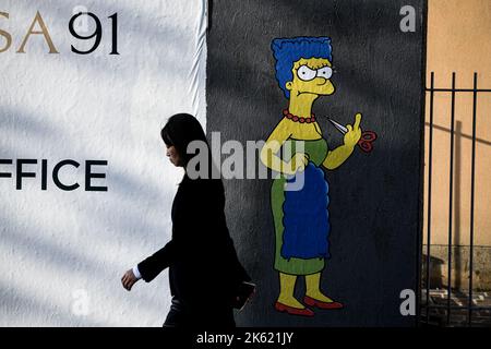 Milan, Italie. 11th octobre 2022. Milan, Italie - 11 octobre 2022: Une femme passe devant une fresque intitulée "The Cut 2" de l'artiste de rue aleXsandro Palombo représentant le personnage des Simpsons Marge Simpson coupant ses cheveux et donnant le doigt du milieu en solidarité avec les femmes d'Iran devant le consulat iranien. Une première version d'une murale similaire, intitulée 'la coupe' est apparue sur 5 octobre au même endroit et a été supprimée plus tard. (Photo de Piero Cruciatti/Sipa USA) crédit: SIPA USA/Alay Live News Banque D'Images