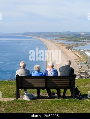 Fortuneswell, Portland, Dorset, Royaume-Uni. 11th octobre 2022. Météo Royaume-Uni. Les visiteurs du point de vue de The Heights, au-dessus de Fortuneswell, sur l'île de Portland à Dorset, ont une vue spectaculaire sur la plage de Chesil et la côte jurassique, le temps d'un après-midi ensoleillé et chaud. Crédit photo : Graham Hunt/Alamy Live News Banque D'Images