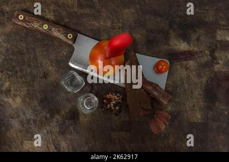 Une vue de dessus de la viande et des légumes sur un cale sur une table en bois avec de petits shooters en verre Banque D'Images