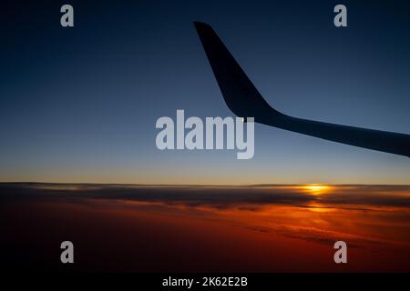 Une aile d'avion au coucher du soleil. Banque D'Images