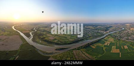 Vue aérienne de la rivière qui coule tranquillement dans la campagne entre les champs verts en soirée d'été Banque D'Images
