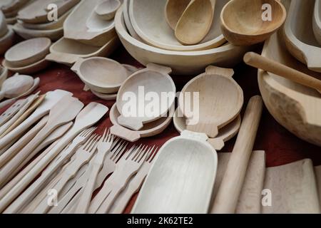 Détails de faible profondeur de champ (mise au point sélective) avec les ustensiles de cuisine roumains traditionnels fabriqués à la main en bois (bols, spatules, fourchettes, cuillères). Banque D'Images