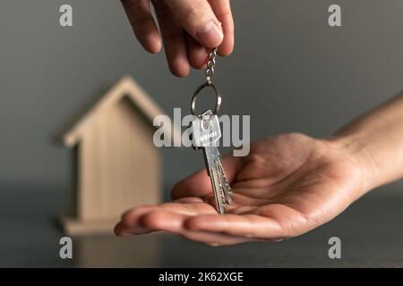 Main de femme recevant les clés de sa nouvelle maison possédée ou louée. Banque D'Images