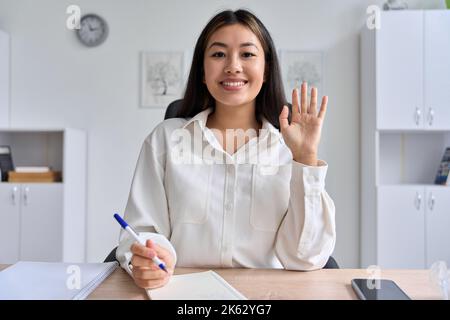 Web CAM View sur la jeune femme d'affaires asiatique agitant les mains de faire des appels vidéo Banque D'Images
