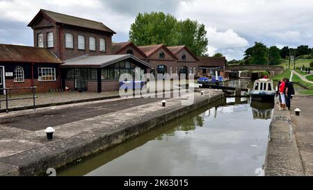 Centre des visiteurs et bateau passant par les portes d'écluse en chemin sur le vol de 21 écluses à Hatton écluses sur le Grand Union Canal, Warwick, Warwickshire Banque D'Images