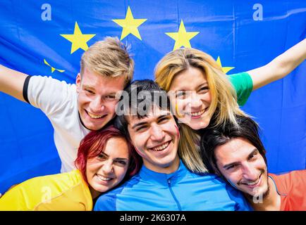Les jeunes supporters de football applaudissent avec le drapeau européen - des gens heureux avec des tee-shirts de football multicolores qui s'amusent au match de championnat de sport - vous Banque D'Images