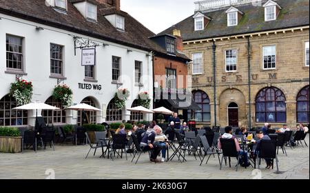 Les gens se trouvent à l'extérieur pour manger, prendre un verre devant l'hôtel avec lit et petit déjeuner incliné Wig et la maison publique sur la place de Warwick Banque D'Images