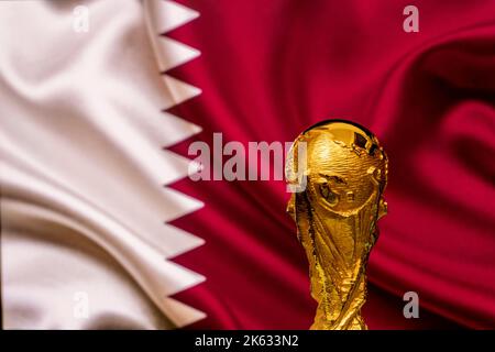 Trophée de la coupe du monde de la FIFA sur fond de drapeau du Qatar. Banque D'Images