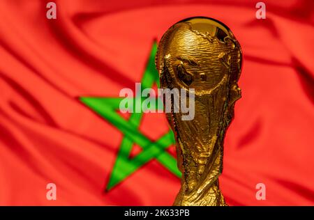 Trophée de la coupe du monde de la FIFA sur fond de drapeau marocain. Banque D'Images