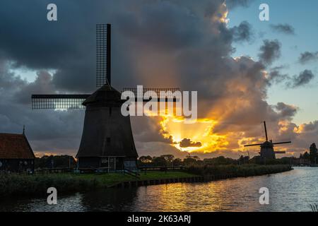 Coucher de soleil spectaculaire avec silhouettes de moulins à vent historiques hollandais le long du canal dans la ville d'Alkmaar Banque D'Images