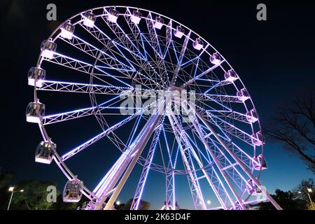 Grande roue de ferris la nuit, illuminant avec des lumières la nuit Banque D'Images