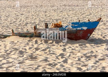 Petit bateau de pêche cassé par une tempête et abandonné sur une plage de l'île de Sal au Cap-Vert, Afrique. Banque D'Images