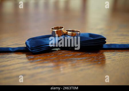 les anneaux de mariage dorés reposent sur un noeud papillon d'homme Banque D'Images