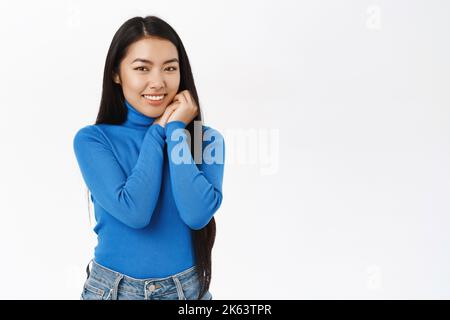 Mignon et tendre, féminine asiatique fille, fait des lèvres de bisous visage, regarde flirty et coquettish, se dresse sur fond blanc Banque D'Images