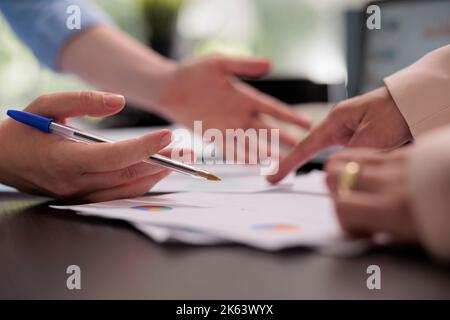 Collaborateurs analysant le rapport financier sur la réunion, planifiant le budget de l'entreprise, gros plan sur les mains, femme pointant sur les graphiques. Collègues travail d'équipe, démarrer le concept d'information sur l'investissement du projet Banque D'Images