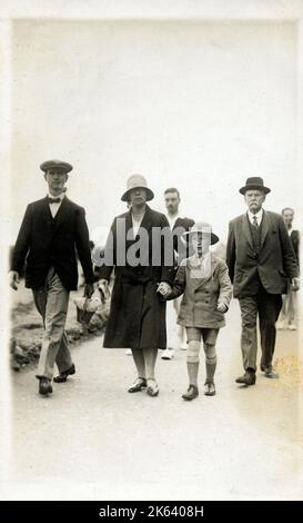 Trois générations de la même famille se promener (un peu misérablement!) Le long du front de mer à Bournemouth, Devon. Banque D'Images