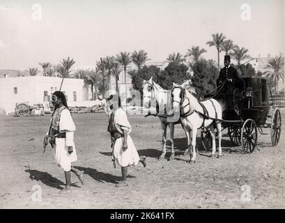 Photographie vintage du 19th siècle : chariot tiré par des chevaux avec des sais courrant ou des hommes de pied en face, le Caire, l'Egypte, le studio Zangaki Banque D'Images