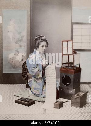 Geisha japonais dans un kimono orné écrivant une lettre. Photographie vintage du 19th siècle. Banque D'Images