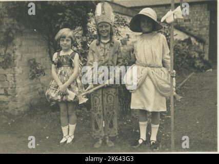 Trois enfants en robe fantaisie, un comme petit Bo-peep, un autre comme un Amérindien.. Banque D'Images