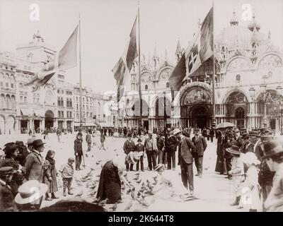 Vintage 19e siècle/1900 photographie:touristes nourrissant des pigeons sur la place Saint-Marc, Venise, Italie Banque D'Images