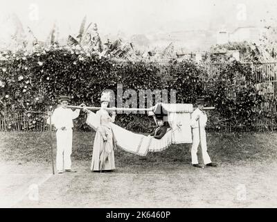 Photographie vintage du 19th siècle - femme en train d'être carriée dans un hamac, portant une chaise, probablement Madère ou les îles Canaries. Banque D'Images