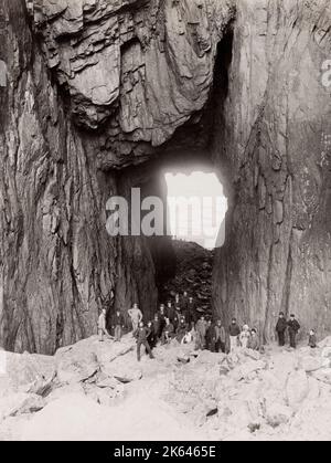 Photographie vintage du 19e siècle : Torghatten est une montagne de granit sur l'île de Torget dans la municipalité de Bronnoy dans le comté de Nordland, en Norvège. Il est connu pour son trou caractéristique. Groupe de touristes. Banque D'Images