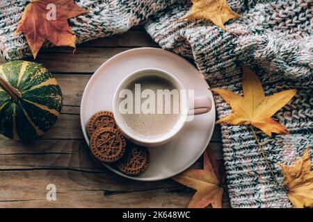 Tasse à café avec biscuits, citrouille, feuilles d'automne et chandail tricoté sur table en bois. Concept d'automne. Vue de dessus, plan d'appartement Banque D'Images