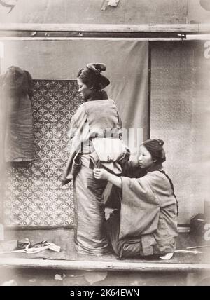 Photographie vintage du XIXe siècle : femme ayant la ceinture obi attachée au-dessus de son kimono, Japon. Du magazine Far East, 1870. Banque D'Images