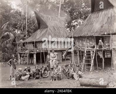 Photographie vintage du XIXe siècle : Singapour, groupe de familles indigènes à l'extérieur de leur maison. Banque D'Images