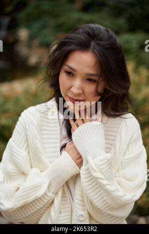 Gros plan belle asiatique kazakh brunette femme noir cheveux longs n confortable saison d'automne. Banque D'Images