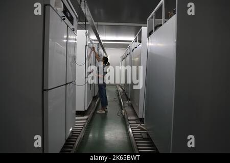 BINZHOU, CHINE - 12 OCTOBRE 2022 - Un travailleur utilise des appareils intelligents pour produire des ustensiles de cuisine dans un atelier d'une entreprise de fabrication d'ustensiles de cuisine à Banque D'Images