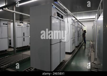 BINZHOU, CHINE - 12 OCTOBRE 2022 - Un travailleur utilise des appareils intelligents pour produire des ustensiles de cuisine dans un atelier d'une entreprise de fabrication d'ustensiles de cuisine à Banque D'Images