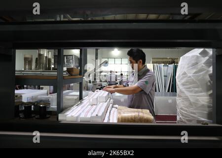 BINZHOU, CHINE - 12 OCTOBRE 2022 - Un travailleur utilise des appareils intelligents pour produire des ustensiles de cuisine dans un atelier d'une entreprise de fabrication d'ustensiles de cuisine à Banque D'Images