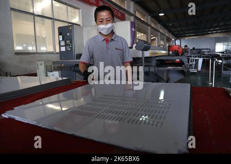 BINZHOU, CHINE - 12 OCTOBRE 2022 - Un travailleur utilise des appareils intelligents pour produire des ustensiles de cuisine dans un atelier d'une entreprise de fabrication d'ustensiles de cuisine à Banque D'Images