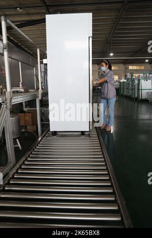 BINZHOU, CHINE - 12 OCTOBRE 2022 - Un travailleur utilise des appareils intelligents pour produire des ustensiles de cuisine dans un atelier d'une entreprise de fabrication d'ustensiles de cuisine à Banque D'Images