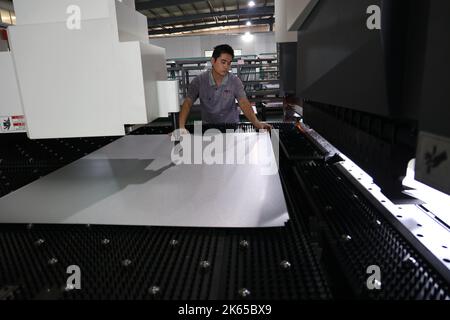 BINZHOU, CHINE - 12 OCTOBRE 2022 - Un travailleur utilise des appareils intelligents pour produire des ustensiles de cuisine dans un atelier d'une entreprise de fabrication d'ustensiles de cuisine à Banque D'Images