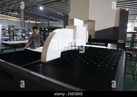 BINZHOU, CHINE - 12 OCTOBRE 2022 - Un travailleur utilise des appareils intelligents pour produire des ustensiles de cuisine dans un atelier d'une entreprise de fabrication d'ustensiles de cuisine à Banque D'Images