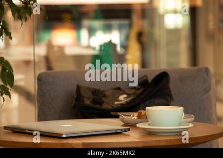 Ukraine Dnipro 15.07.2021 - Apple MacBook portable et une tasse de café sur la table dans un café sur une pause, travaillant à un ordinateur portable dans un café, ordinateur portable sur le t Banque D'Images