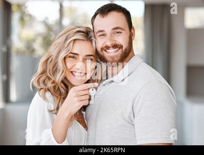 Portrait d'un couple caucasien heureux tenant les clés de la maison. Un couple affectueux se réjouit après avoir acheté sa première maison ou sa nouvelle maison. Joyeux et joyeux Banque D'Images