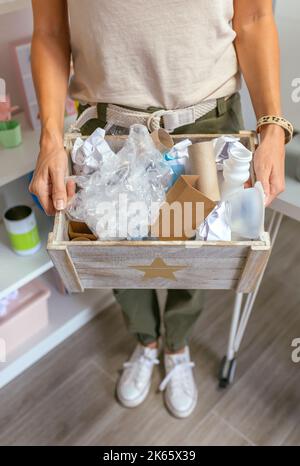 Une enseignante montrant une boîte de déchets à recycler en classe écologique Banque D'Images