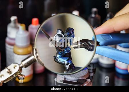 Loupe géante pour faciliter la peinture de petites figures de jeux de société utilisés pour les jeux de rôle Banque D'Images