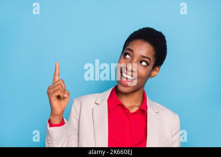 Portrait de la personne positive l'aspect indique doigt vide espace isolé sur fond bleu Banque D'Images