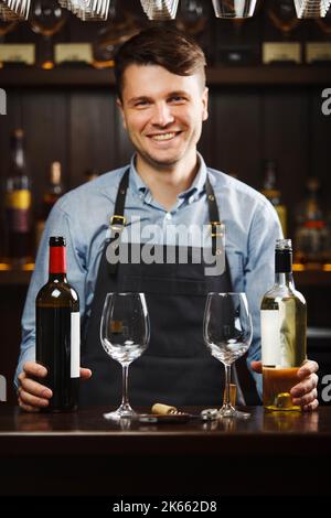 Sommelier avec des bouteilles de vin rouge et blanc et des verres à vin Banque D'Images