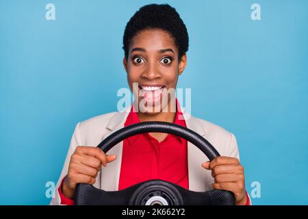 Portrait de la personne excitée étonnée tient la roue bouche ouverte isolée sur fond bleu Banque D'Images