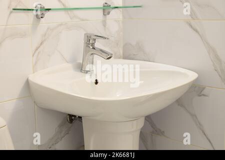 Lavabo dans la salle de bains et robinet avec eau froide et chaude, plomberie Banque D'Images