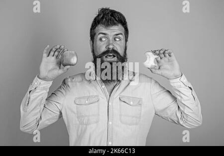 Fruits en-cas sain toujours bonne idée. La belle barbe hipster longue de l'homme tient la pomme mûre et la souche de pomme presque mangée. L'alimentation de l'homme mange des fruits Banque D'Images